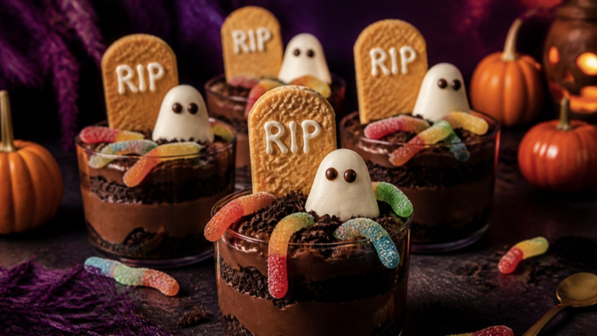 Halloween graveyard dirt cups with chocolate pudding, gummy worms, RIP biscuit tombstones and ghosts
